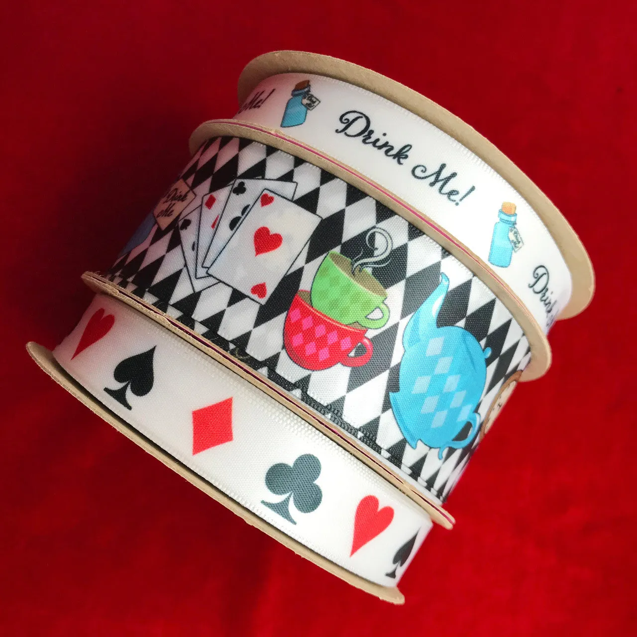 Alice in Wonderland ribbon with all the elements of her story on a black and white harlequin background printed on 1.5" white single face satin